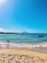 a group of people on a beach with a boat in the water